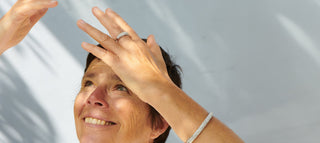 Eine Frau hat einen schönen Ring am Finger, von oben blendet die Sonne.